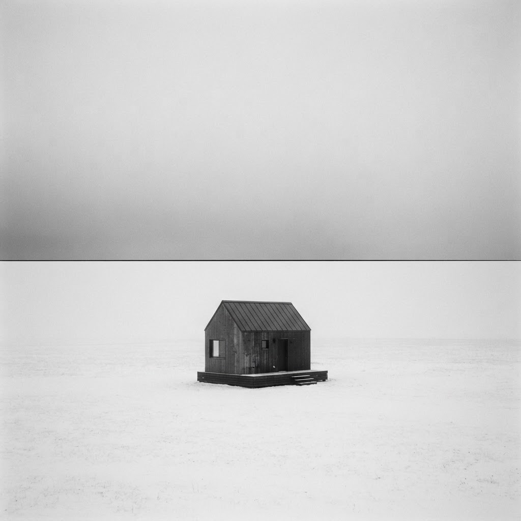 A calm monochrome horizon with a single anchored form.