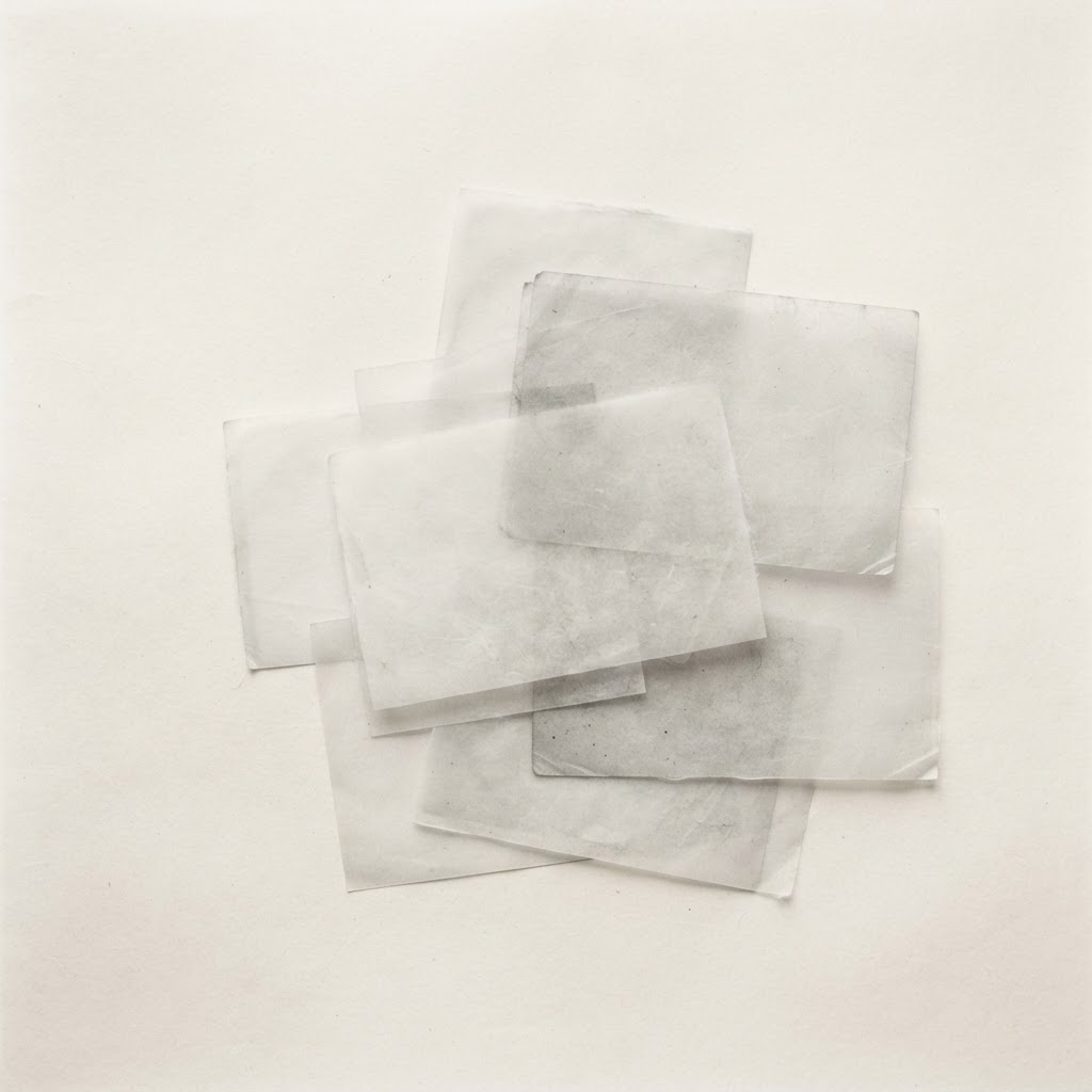 A quiet grid of layered notes fading into the page, in monochrome.
